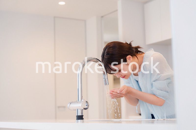 家で洗顔をする若い女性