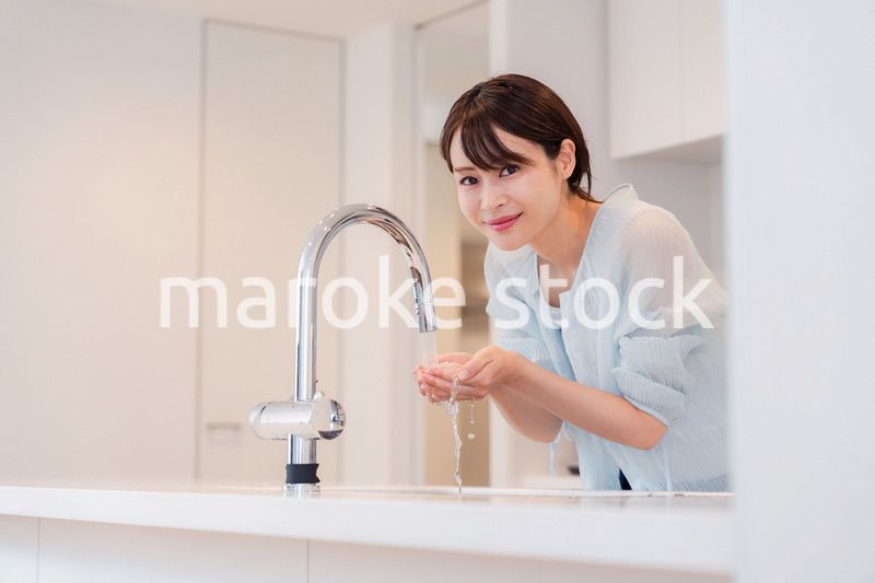 家で洗顔をする若い女性