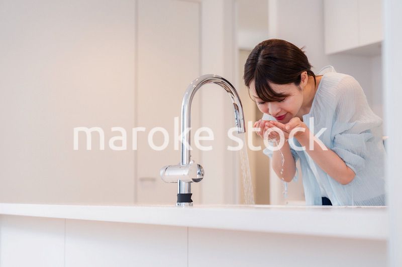 家で洗顔をする若い女性