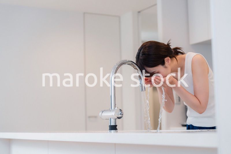 家で洗顔をする若い女性