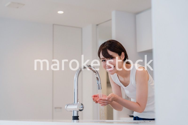 家で洗顔をする若い女性