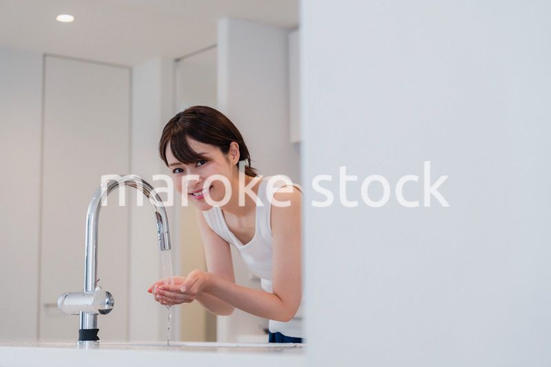 家で洗顔をする若い女性