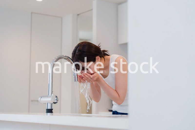 家で洗顔をする若い女性
