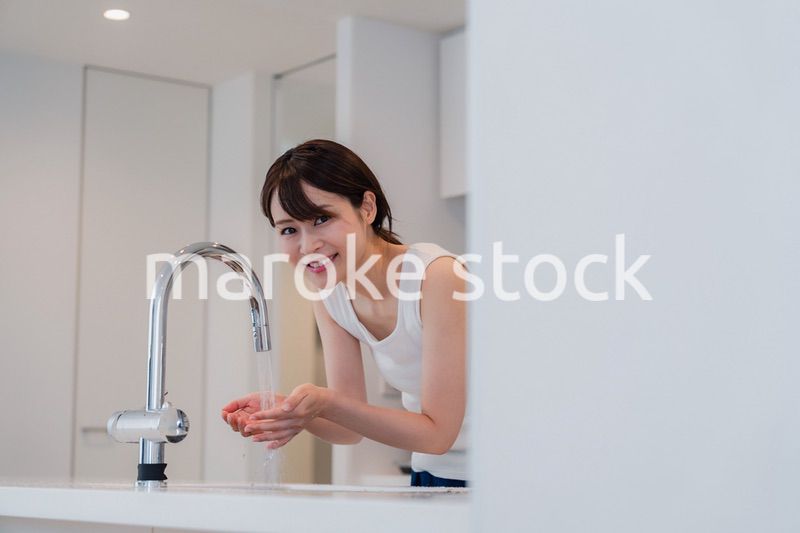 家で洗顔をする若い女性