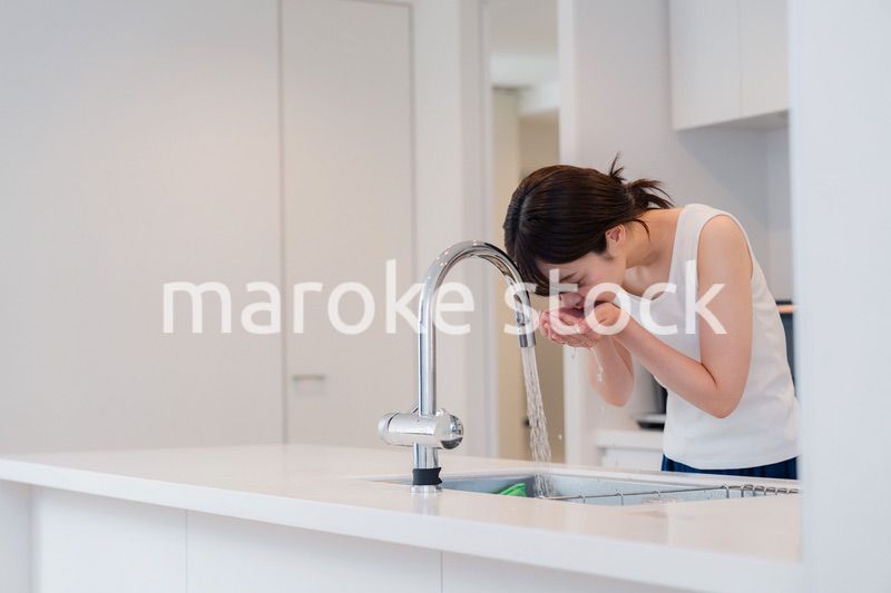 家で洗顔をする若い女性