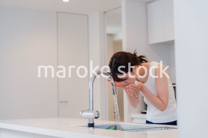 家で洗顔をする若い女性