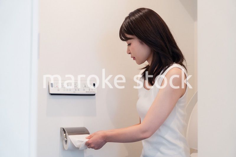 トイレットペーパーを引っ張る若い女性