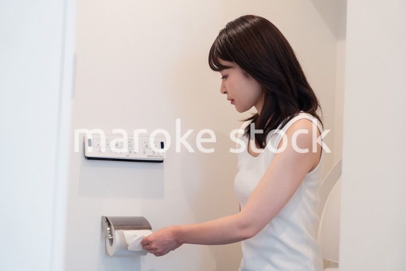トイレットペーパーを引っ張る若い女性