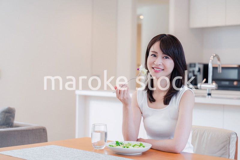 家でご飯を食べる若い女性