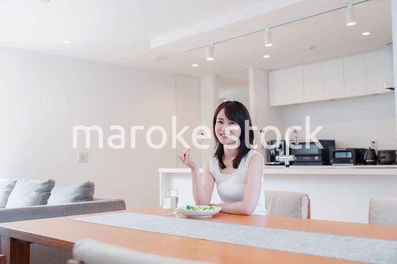 家でご飯を食べる若い女性