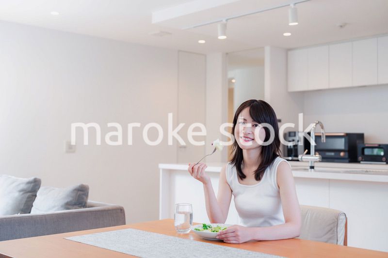 家でご飯を食べる若い女性