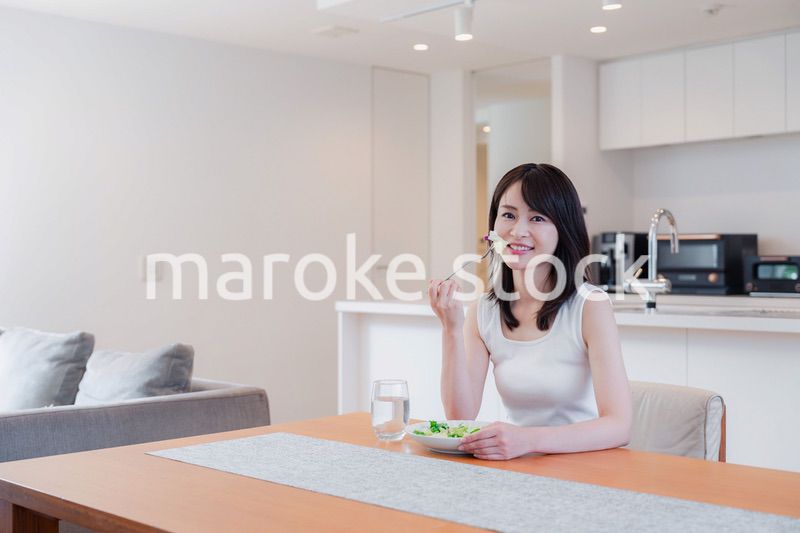 家でご飯を食べる若い女性