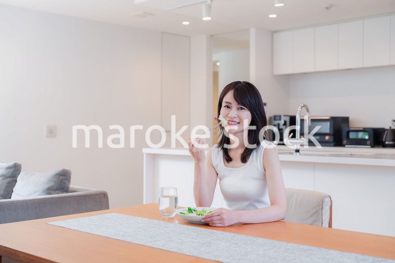 家でご飯を食べる若い女性