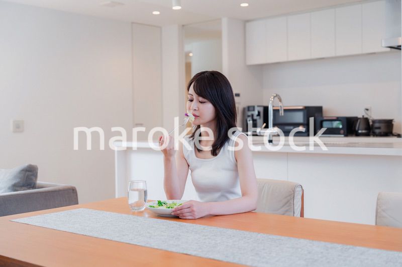 家でご飯を食べる若い女性
