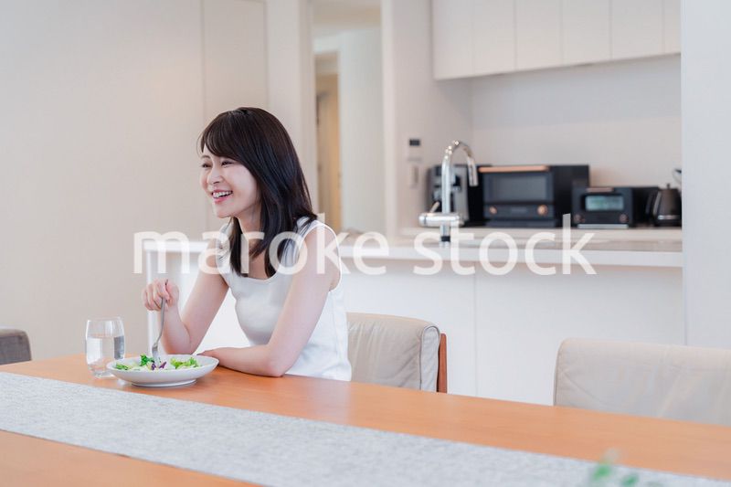 家でご飯を食べる若い女性