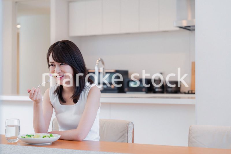 家でご飯を食べる若い女性