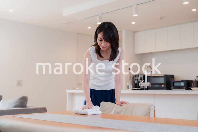 ダイニングテーブルを拭く若い女性