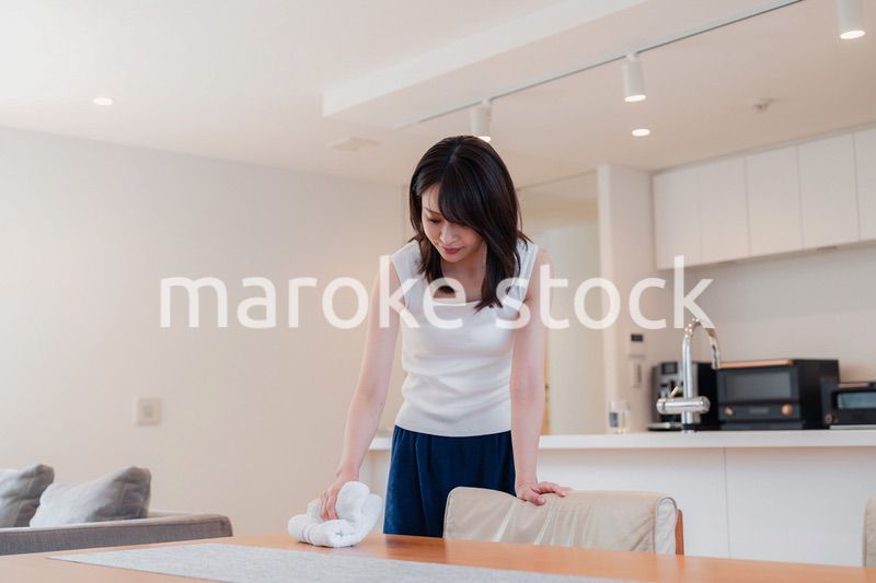 ダイニングテーブルを拭く若い女性