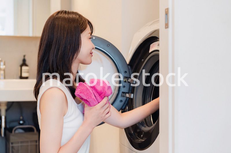 ドラム式洗濯機を使う若い女性
