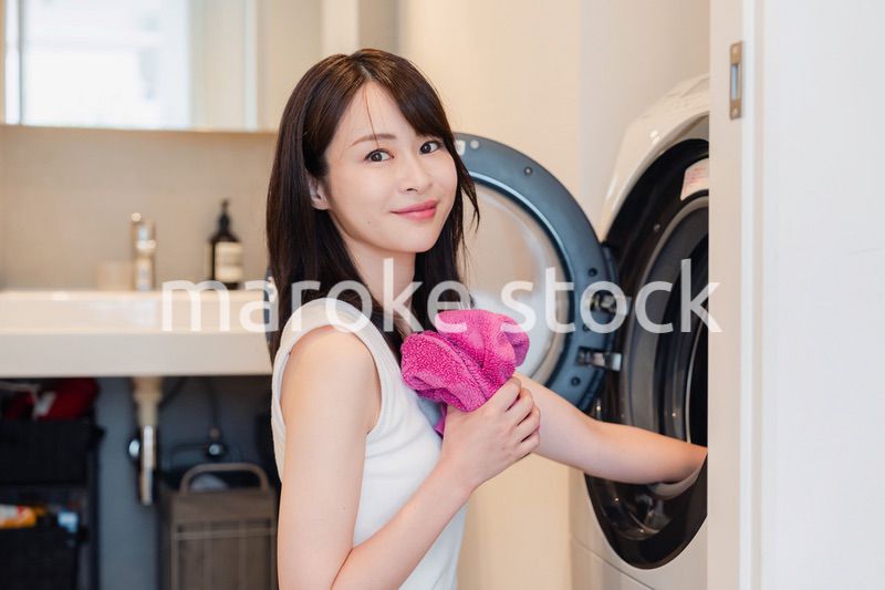 ドラム式洗濯機を使う若い女性