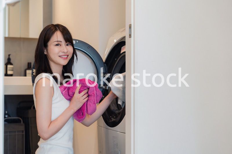 ドラム式洗濯機を使う若い女性