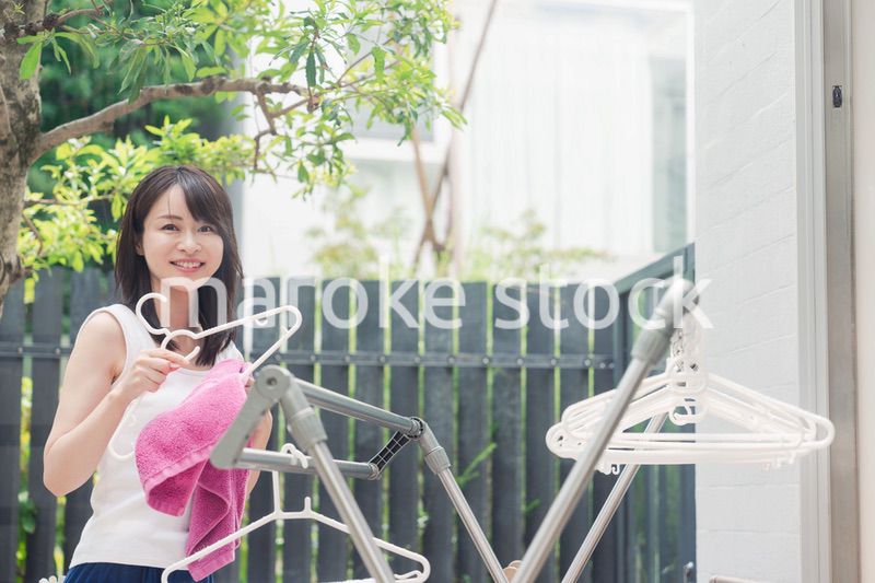 洗濯物を干す若い女性
