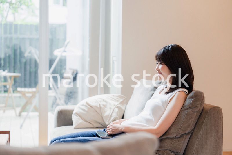 家でテレビを見る若い女性