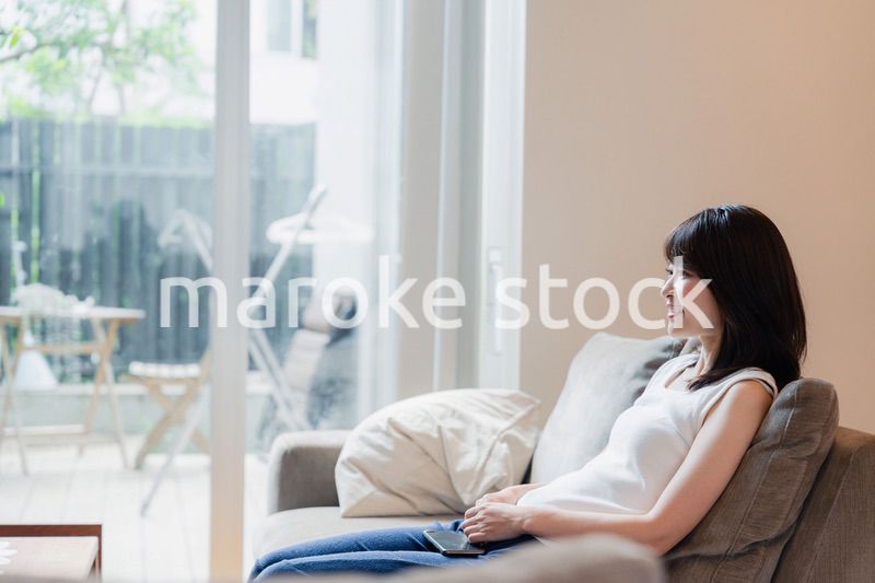 家でテレビを見る若い女性