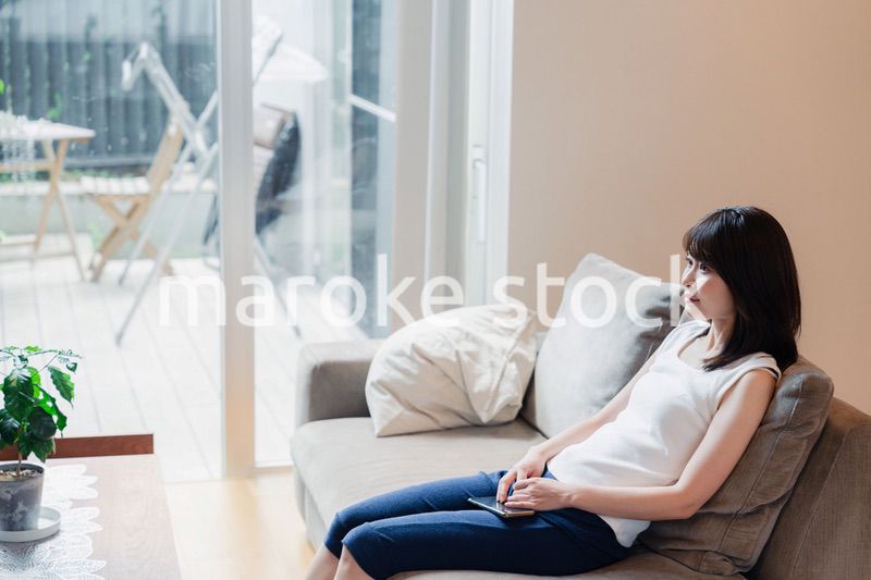 家でテレビを見る若い女性