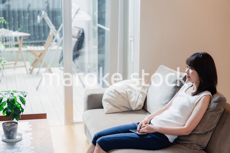 家でテレビを見る若い女性