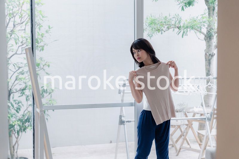 家でファッションの組み合わせを考える若い女性