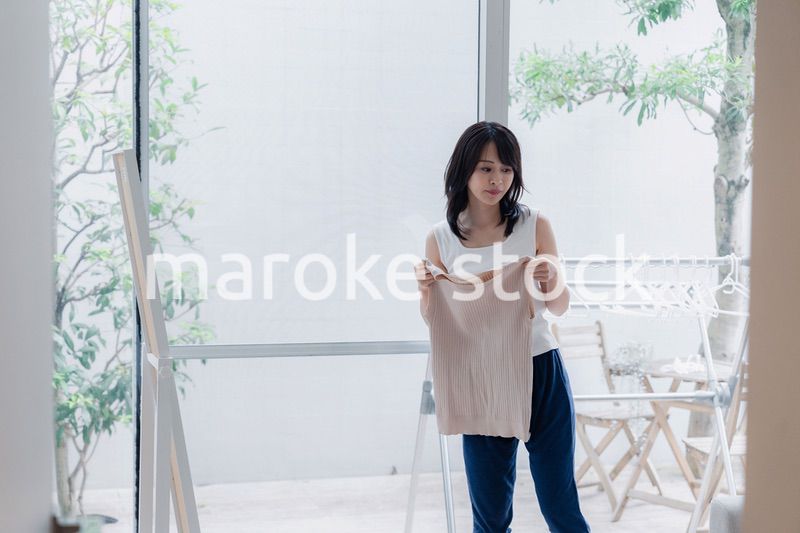 家でファッションの組み合わせを考える若い女性