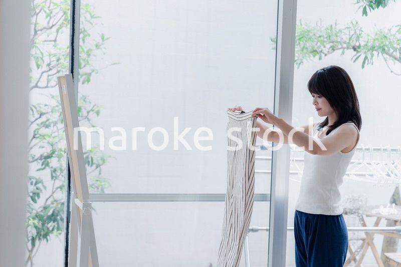 家でファッションの組み合わせを考える若い女性