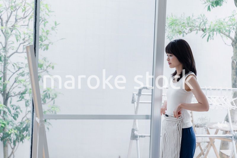 家でファッションの組み合わせを考える若い女性