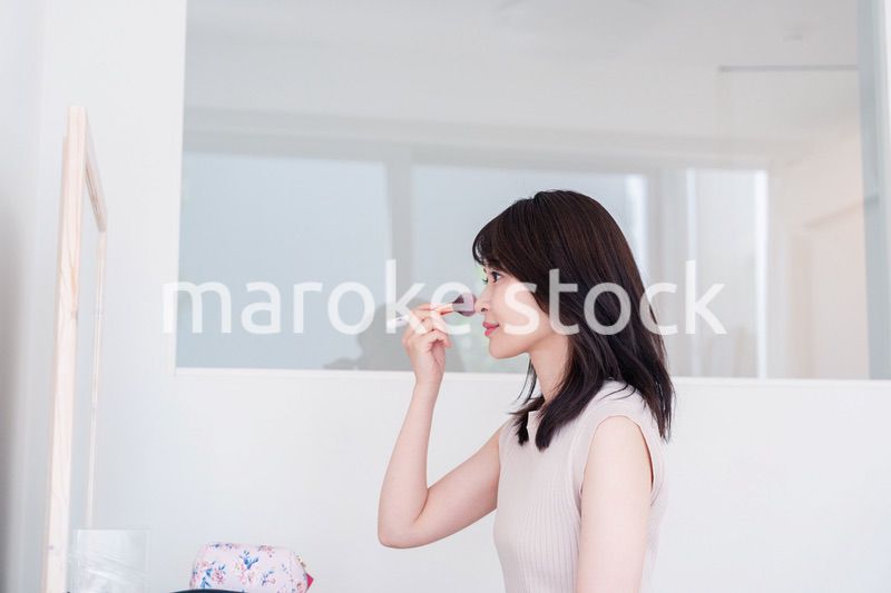 家でメイクをする若い女性
