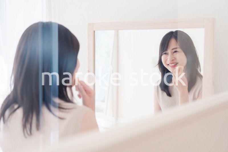 家でメイクをする若い女性