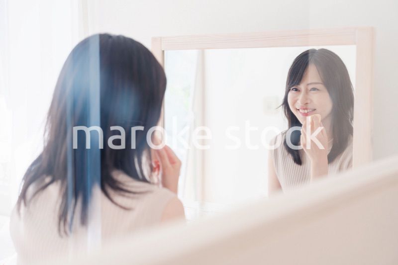 家でメイクをする若い女性