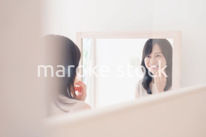 家でメイクをする若い女性