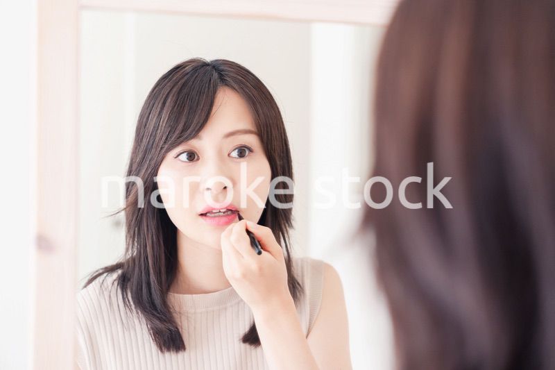 家でメイクをする若い女性