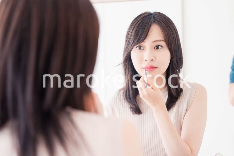 家でメイクをする若い女性