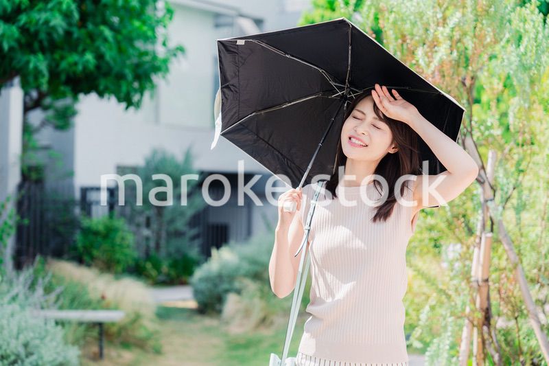 日傘を差して外を歩く若い女性