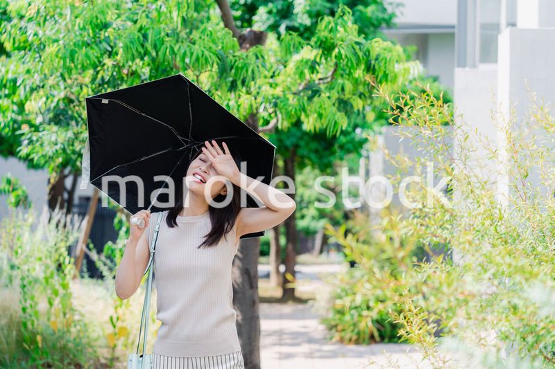 日傘を差して外を歩く若い女性