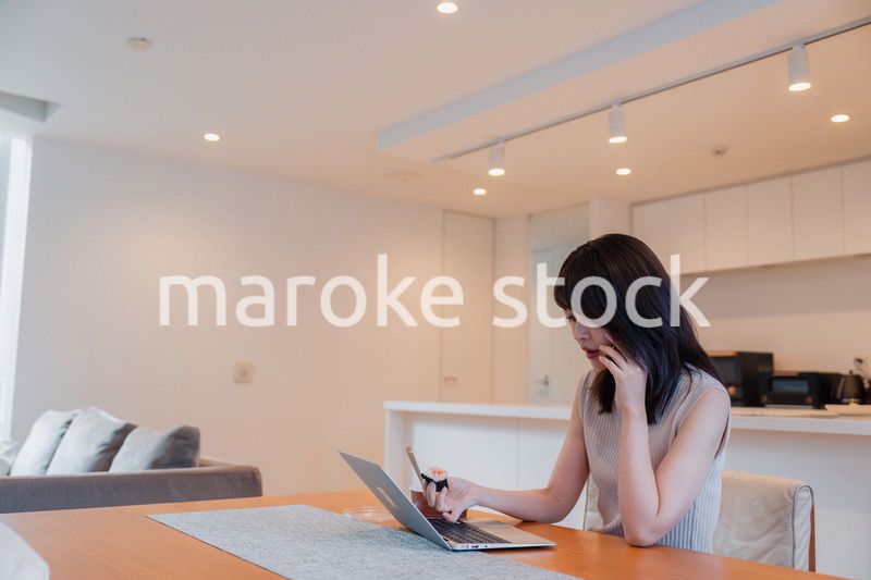 テレワークをしながらごはんを食べる多忙な女性