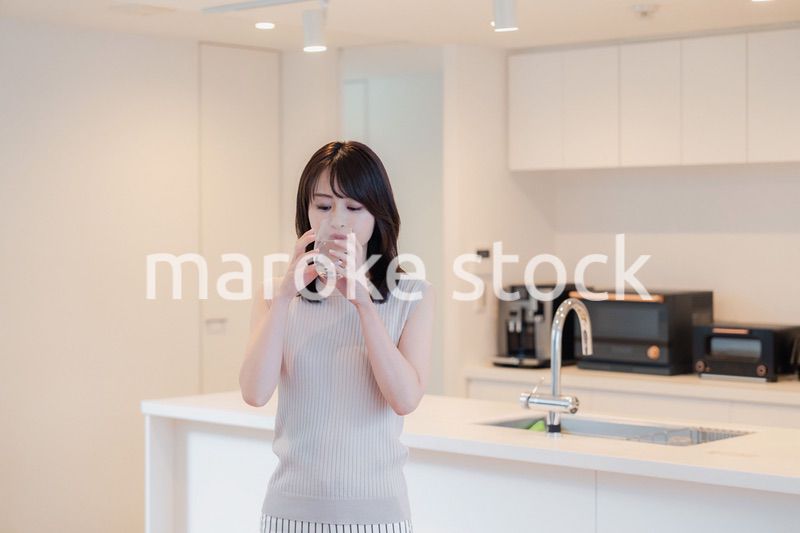 家で水を飲む若い女性