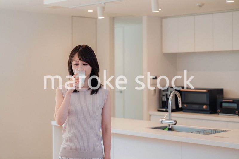 家でミルクを飲む若い女性