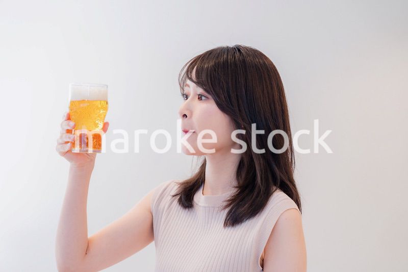 笑顔でビールを飲む若い女性
