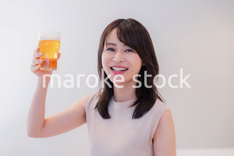 笑顔でビールを飲む若い女性