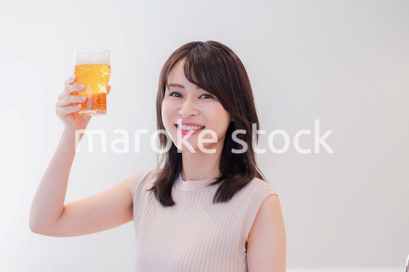 笑顔でビールを飲む若い女性