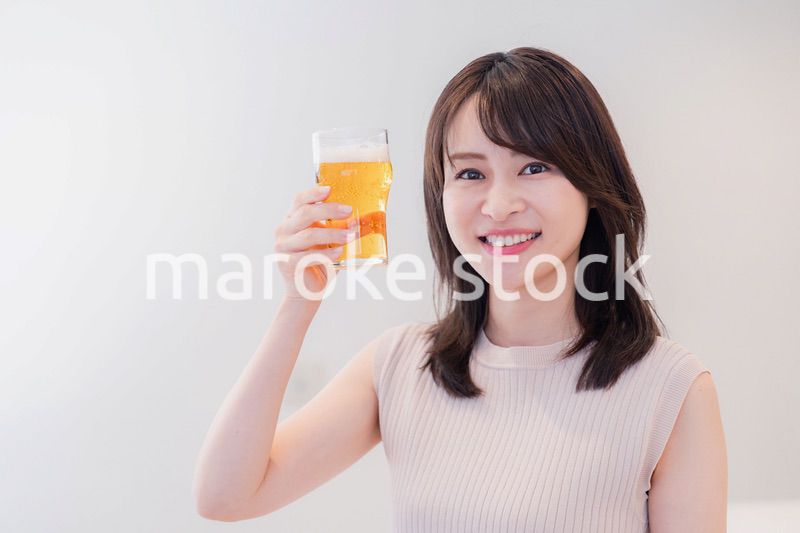 笑顔でビールを飲む若い女性