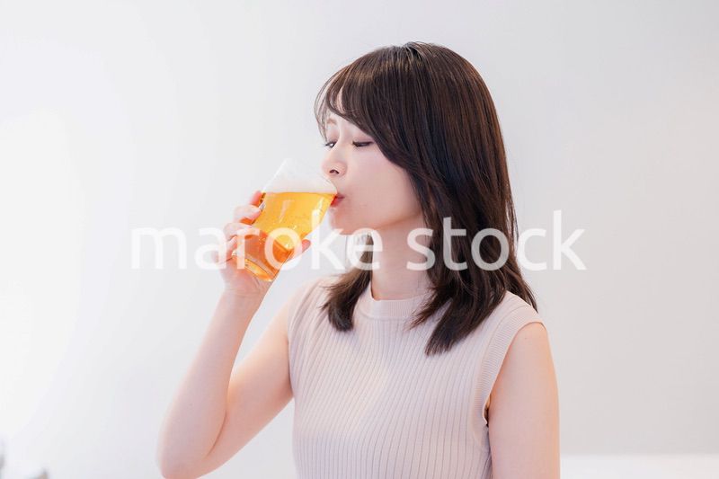 笑顔でビールを飲む若い女性